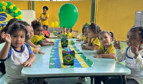 Crianças reunidas à mesa decorada